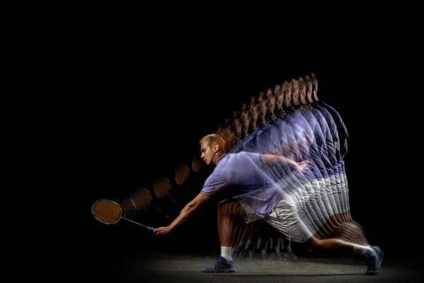 Um jovem jogador de badminton, treino de vaivém isolado em fundo escuro. Efeito estroboscópio. — Fotografia de Stock