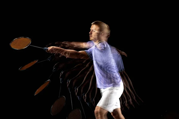 Portrait of young man, male badminton player, shuttler in motion and action on dark background. Stroboscope effect. — Stock fotografie