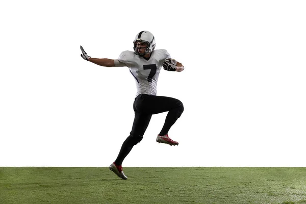 Portrait of American football player training, playing isolated on white studio background with grass cover. — Stock Photo, Image