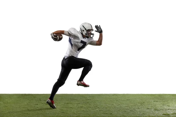 Portrait of American football player training, playing isolated on white studio background with grass cover. — Stock Photo, Image