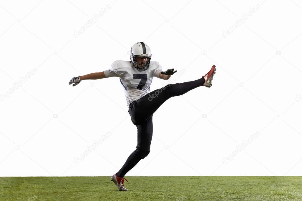 Portrait of American football player training isolated on white studio background with grass covering