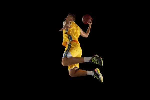 Giovanotto, giocatore di basket con un allenamento di palla isolato su sfondo nero scuro. Concetto pubblicitario. Adatto atleta caucasico che pratica con la palla. — Foto Stock
