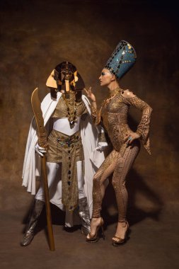 Nefertiti 'nin sanat performansındaki görüntüsü gibi genç bir kadın. Kahverengi renkli arka planda izole edilmiş. Retro biçimi, dönemin karşılaştırması.