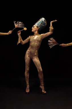 Nefertiti 'nin sanat performansını yansıtan genç ve güzel bir kadın koyu arkaplanda izole tablet kullanıyor. Retro tarzı, çağların karşılaştırılması, mizah anlayışı.