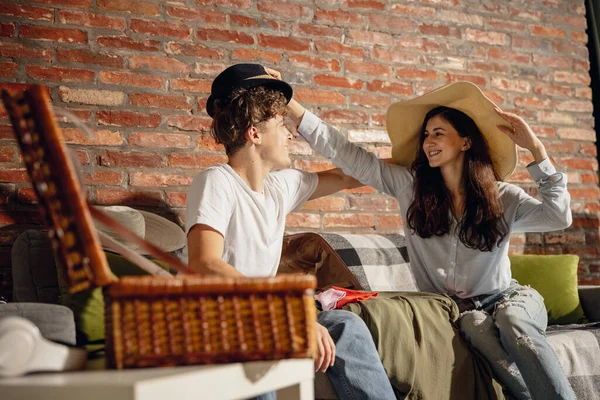 Menina feliz e menino se divertindo, se preparando para férias de verão sentado em casa, dentro de casa. Tomar a decisão certa. Olha animado, encantado. — Fotografia de Stock