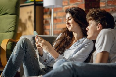 Genç bir çift yaz tatiline hazırlanıyor. Evde, evde oturuyorlar. Mutlu görün, mutlu ol..