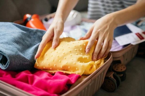 Primer plano manos femeninas maleta de embalaje para las vacaciones de verano, vacaciones en el interior de casa, en el interior. Concepto de moda, belleza, estilo de vida, actividad lesuire. — Foto de Stock