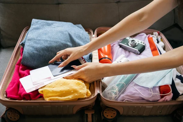 Primer plano manos femeninas maleta de embalaje para las vacaciones de verano, vacaciones en el interior de casa, en el interior. Concepto de moda, belleza, estilo de vida, actividad lesuire. — Foto de Stock