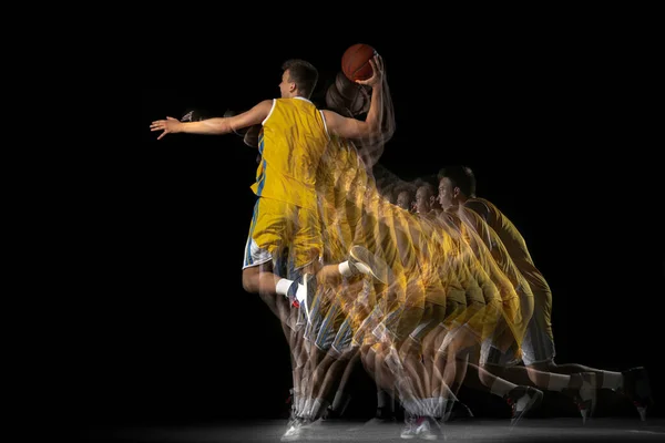 Jovem jogador de basquete caucasiano em movimento e ação isolado em fundo escuro com efeito estroboscópio. Conceito de estilo de vida saudável, esporte profissional, hobby. — Fotografia de Stock