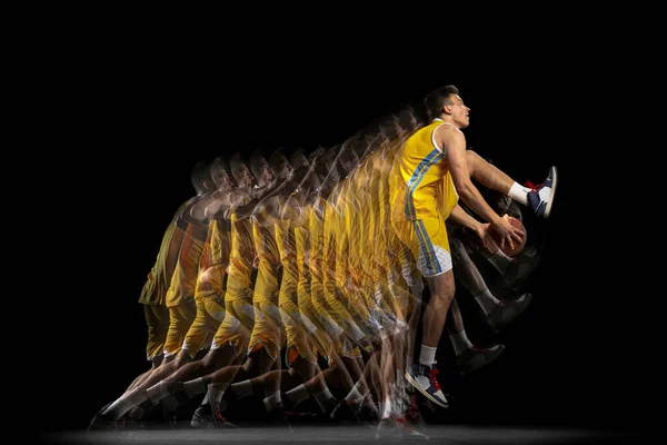 Macht en snelheid. Een jonge basketbalspeler training met bal geïsoleerd op donkere achtergrond met stroboscoop effect. Begrip professionele sport, hobby. — Stockfoto