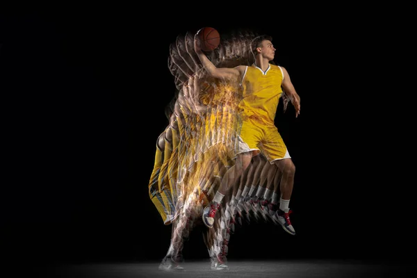 Retrato de un joven jugador de baloncesto entrenando con pelota aislada sobre fondo oscuro con efecto estroboscópico. Concepto de deporte profesional, hobby. — Foto de Stock
