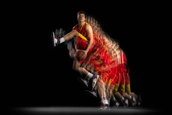 Portret młodego koszykarza trenującego z piłką odizolowaną na ciemnym tle z efektem stroboskopu. Pojęcie sportu zawodowego, hobby. — Zdjęcie stockowe