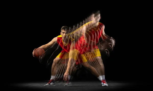 Jogador de basquete profissional jogando basquete isolado em fundo escuro com efeito estroboscópio. Conceito de esporte profissional, hobby. — Fotografia de Stock
