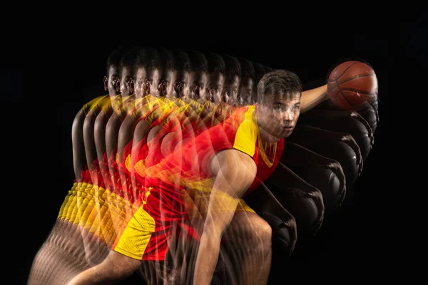 Ένας νεαρός μπασκετμπολίστας προπονείται με μπάλα απομονωμένη σε σκούρο φόντο με εφέ στροβοσκοπίου. Έννοια του επαγγελματικού αθλητισμού, χόμπι. — Φωτογραφία Αρχείου