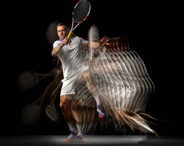 Puissance et vitesse. Jeune homme, joueur de tennis professionnel en mouvement et en action isolé sur fond sombre avec effet stroboscope. — Photo