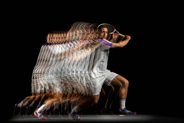 Power and speed. Young man, professional tennis player in motion and action isolated on dark background with stroboscope effect. — Stock Photo, Image