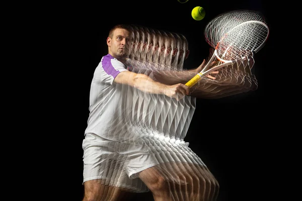 Jeune homme, joueur de tennis professionnel en mouvement et action isolé sur fond sombre. Effet stroboscope. — Photo