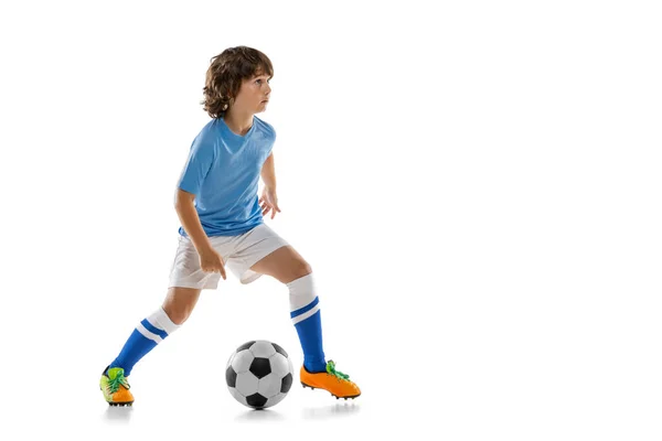 Молодой спортсмен, футболист, ребенок, играющий в футбол изолирован на белом фоне студии. Концепция спорта, игры, хобби — стоковое фото