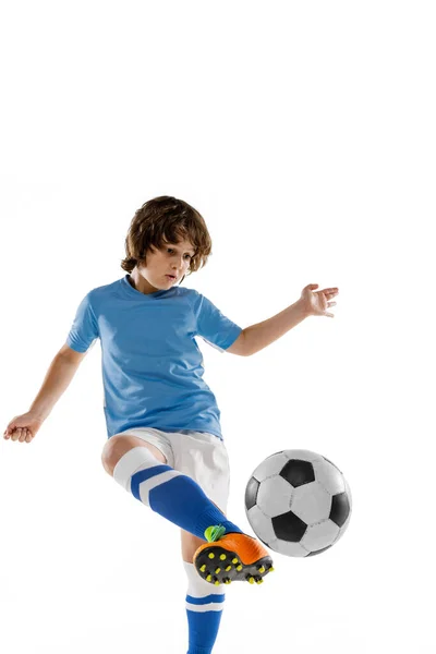 Крупним планом молодий футболіст, хлопчик тренується з футбольним м'ячем ізольовано на білому фоні студії. Концепція спорту, гри, хобі — стокове фото