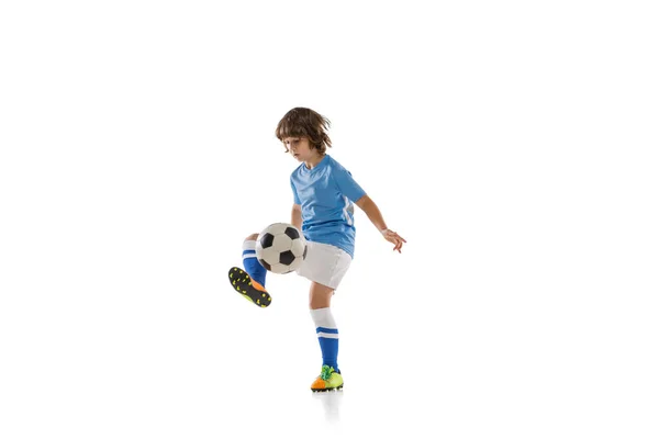 Um menino pré-escolar, jogador de futebol em ação, treinamento de movimento isolado em fundo de estúdio branco. Conceito de esporte, jogo, hobby — Fotografia de Stock
