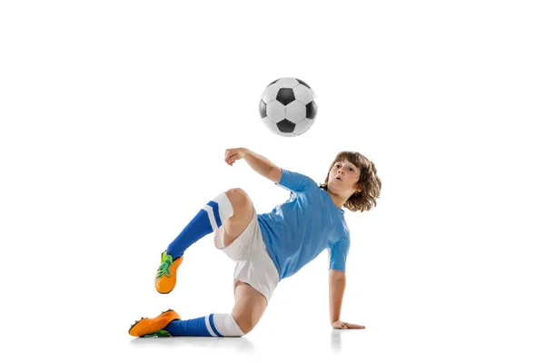 Küçük erkek futbol oyuncusunun portresi, beyaz stüdyo arka planında izole edilmiş futbol topuyla antrenman yapan çocuk. Spor, oyun, hobi kavramı — Stok fotoğraf