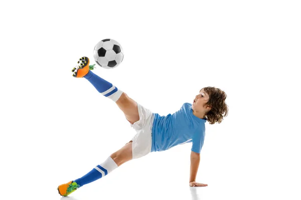 Молодой спортсмен, футболист, ребенок, играющий в футбол изолирован на белом фоне студии. Концепция спорта, игры, хобби — стоковое фото