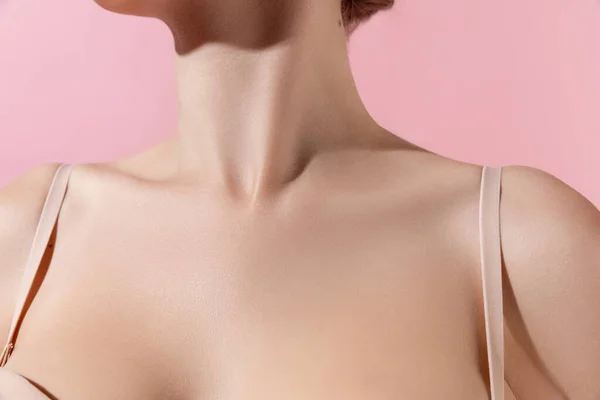 Cercanía del cuello femenino, clavículas aisladas sobre fondo rosa del estudio. Hermosa mujer caucásica con la piel bien cuidada. —  Fotos de Stock