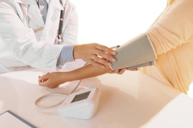 Close-up hands of doctor, therapeutic or medical advisor measuring pressure to patient, sick. Concept of healthcare, care and medicine.