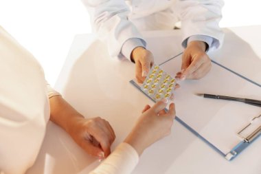 Seek medical advice from doctor. Close-up hands of therapeutic or medical advisor giving pills to patient, sick. Concept of healthcare, care and medicine.