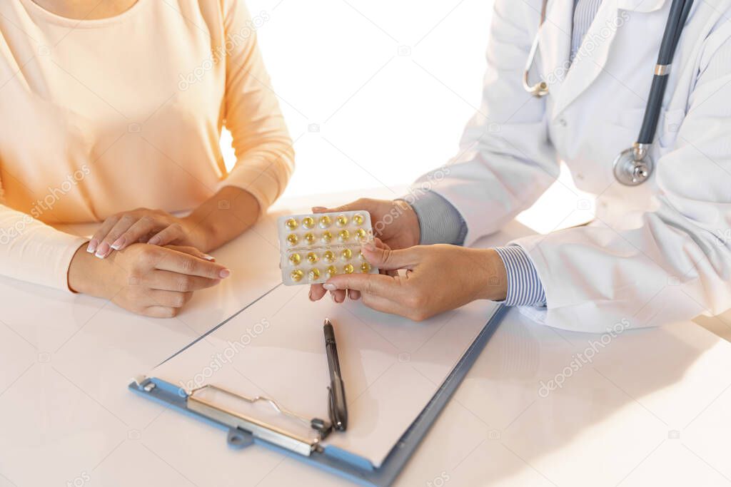 Seek medical advice from doctor. Close-up hands of therapeutic or medical advisor giving pills to patient, sick. Concept of healthcare, care and medicine.