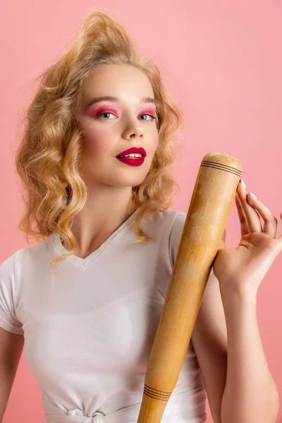 Beautiful young girl with bright makeup and hairdo in retro 90s fashion style in image of Harley Quinn isolated over pink studio background. Concept of eras comparison — Stock Photo, Image