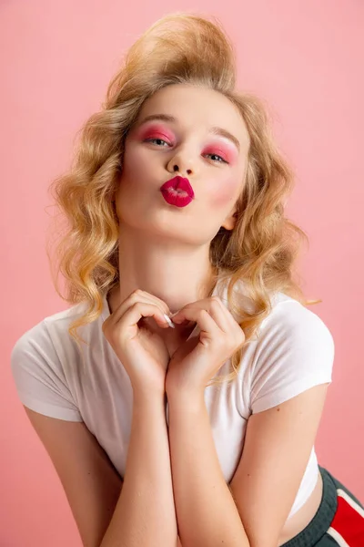 Primer plano adorable chica bonita con maquillaje brillante y peinado en estilo de moda retro años 90 aislado sobre fondo de estudio rosa. Concepto de eras comparación, belleza, moda y juventud. — Foto de Stock