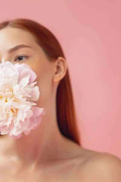 Retrato de colheita de mulher ruiva bonita com flor isolada sobre estúdio rosa de volta chão. Cor nua, dieta, cosméticos, beleza natural e conceito de cosmetologia estética. — Fotografia de Stock