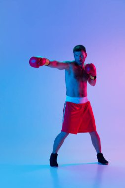 Beyaz adam, profesyonel boksör spor giyim boksörü stüdyo arka planında, neon ışıklı. Spor, aktivite, hareket, refah kavramı.