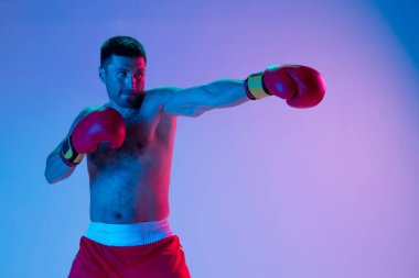 Beyaz adam, profesyonel boksör spor giyim boksörü stüdyo arka planında, neon ışıklı. Spor, aktivite, hareket, refah kavramı.