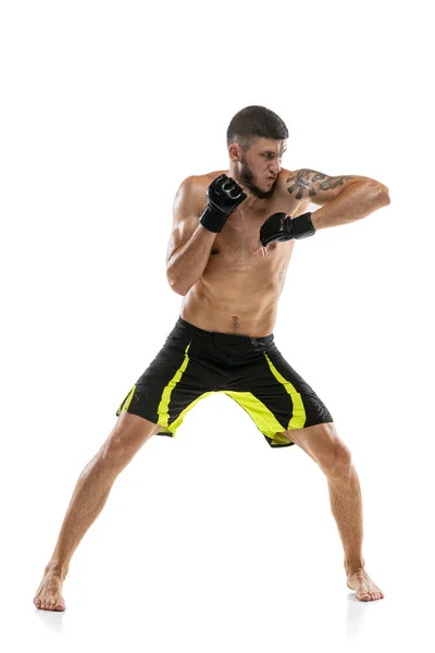Un hombre, boxeador profesional masculino MMA en movimiento aislado sobre fondo blanco del estudio. Ajuste muscular caucásico atleta lucha. — Foto de Stock