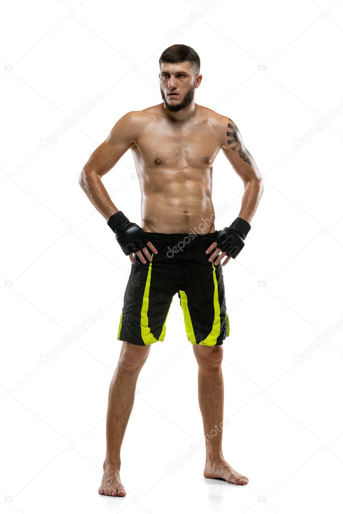 Full-length portrait of Caucasian athlete, professional male MMA boxer isolated on white studio background. Sport, competition and human emotions concept.
