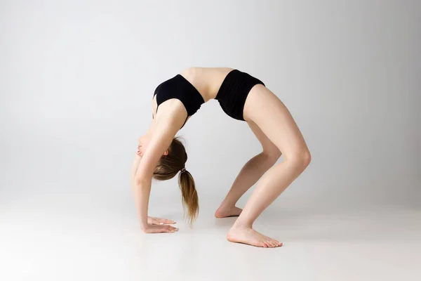 Chica adorable flexible en lencería negra posando aislado sobre fondo gris estudio. Belleza natural, spa, cosmética, fitness y cosmetología estética. —  Fotos de Stock