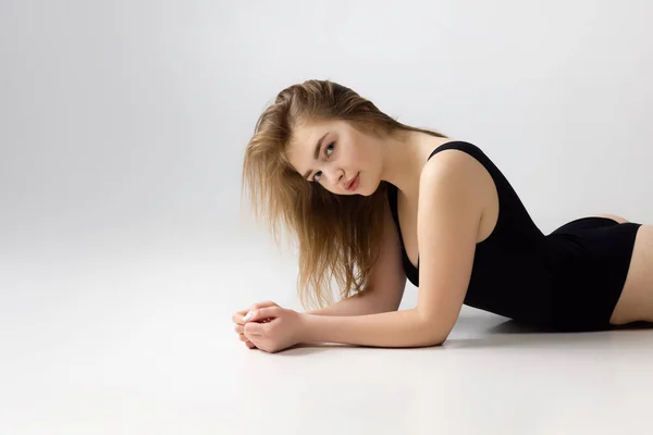 Fiatal bájos lány fekete fehérnemű pózol elszigetelt felett szürke stúdió háttér. Természetes szépség, spa, kozmetika, fitness és esztétikai kozmetikai koncepció. — Stock Fotó