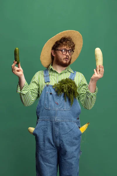 Vöröshajú szakállas férfi, zöldséges aratású farmer, zöld stúdió háttérrel elszigetelve. A szakmai foglalkozás fogalma, munka. — Stock Fotó