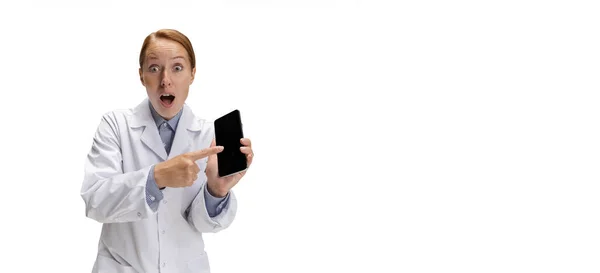 Using phone. Portrait of female doctor, therapeutic or medical advisor showing smartphone screen. Funny meme emotions. Concept of healthcare, care medicine and humor — Stock Photo, Image