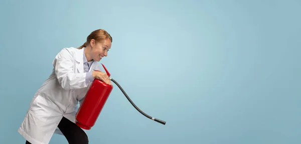 Portrait of young woman, doctor, therapeutic or medical advisor with extinguisher isolated on blue background. Funny meme emotions. — Stock Photo, Image