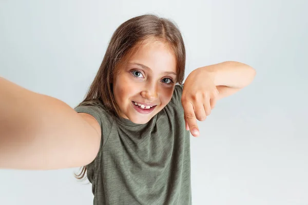 Gros plan portrait de belle fille souriante préscolaire regardant la caméra isolée sur fond de studio blanc. Espace de copie pour la publicité. Enfance, éducation, concept émotionnel — Photo