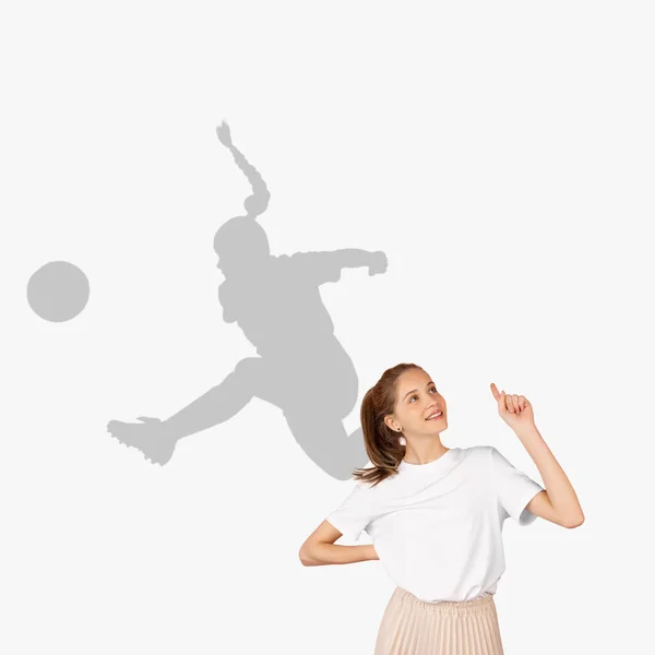 Jong mooi meisje droomt over toekomstige carrière in de sport. Ik word een geweldige footballspeler. Dromenschaduw op de muur achter haar. Copyspace voor reclame. — Stockfoto