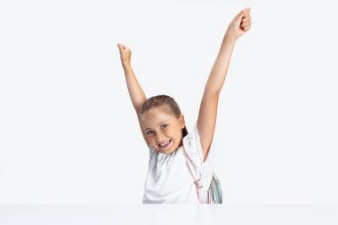 Okula dönelim. Beyaz stüdyo arka planında izole edilmiş kameraya bakan mutlu beyaz kız öğrenci. Kopyalama. Çocukluk, eğitim, duygu kavramı