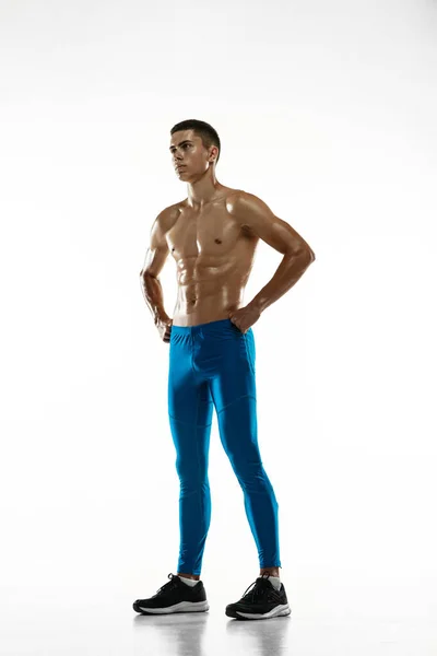 Portret van jonge gespierde man, mannelijke atleet, hardloper geïsoleerd op witte studio achtergrond. Concept sport, gezonde levensstijl. Macht en schoonheid — Stockfoto