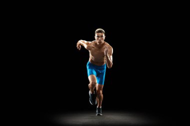 Kafkas profesyonel erkek atlet portresi, atlet eğitimi karanlık stüdyo arka planında izole edilmiş. Kaslı, sportif bir adam. Spor anlayışı, sağlıklı yaşam tarzı