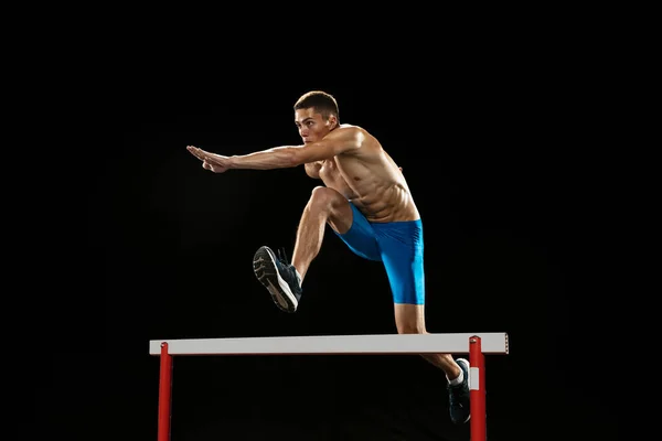 Portrait of Caucasian professional male athlete, runner training isolated on dark studio background. Muscular, sportive man. Concept of sport, healthy lifestyle — Stock Photo, Image