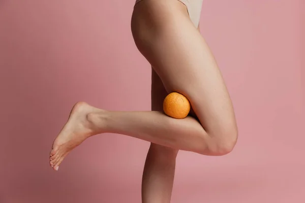 Image recadrée de mince jeune belle femme bronzée en lingerie posant isolée sur fond de studio rose. Beauté naturelle, concept de traitement anti-cellulite. — Photo