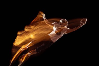 Genç bir adamın portresi, Amerikan futbolcu eğitimi karanlık stüdyo arka planında izole edilmiş, karışık neon ışıklı. Spor, rekabet ve güzellik kavramı